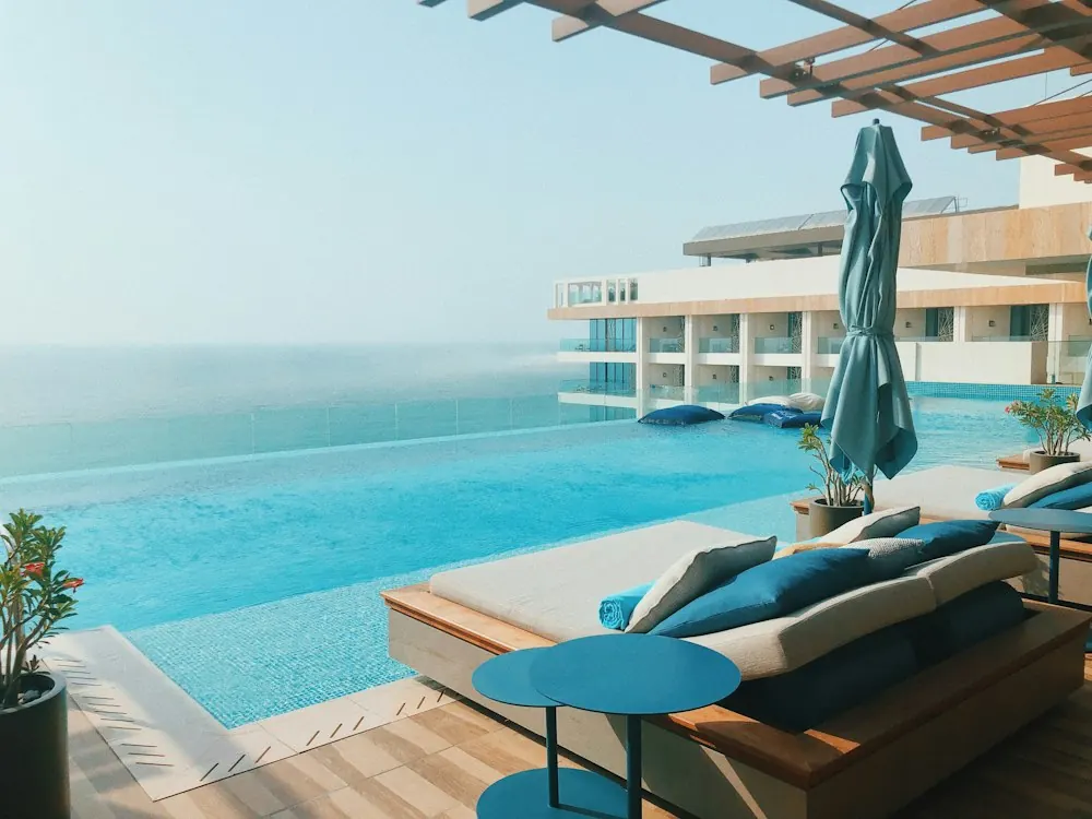 Zona de descanso de un hotel junto a la piscina, con tumbonas y parasoles